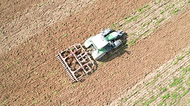 Banner del GNSS en la agricultura moderna con título del artículo y fecha sobre fondo gris abstracto.