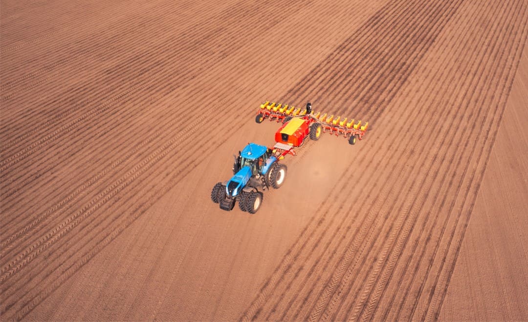Tractor with autosteering preparing soil for precision seeding