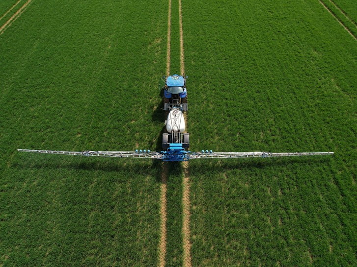 CHCNAV SprayX100 intelligent spraying system on a tractor sprayer in a field