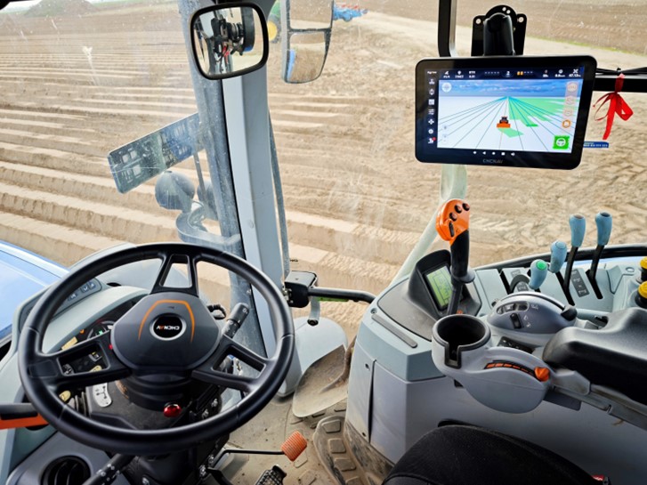 CHCNAV auto-steering display inside a tractor cabin.
